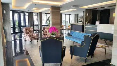 a lobby with a blue bench and a table and chairs at Manhattan Hotel Ipoh in Ipoh