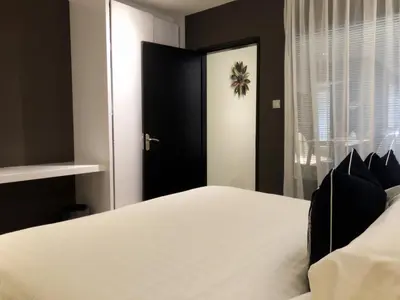 a bedroom with a white bed and a black door at M Roof Hotel & Residences in Ipoh