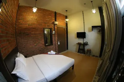 a room with a bed and a brick wall at JQ Ban Loong Boutique Hotel in Ipoh