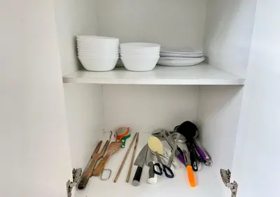 a white shelf with bowls and utensils on it at Play Residence at Golden Hills in Cameron Highlands