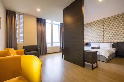 a hotel room with a bed and a yellow couch at OMG Hotel in Simpang Ampat