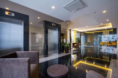 a lobby with chairs and a table in a building at OMG Hotel in Simpang Ampat