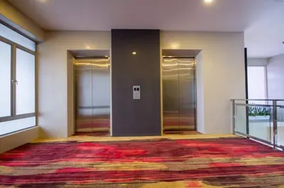 an empty hallway with three elevators in a building at OMG Hotel in Simpang Ampat