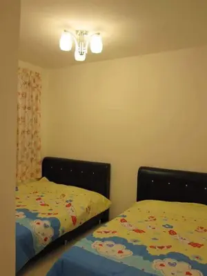a bedroom with two twin beds and a light at SA Apartments @ Crown Imperial Court in Cameron Highlands