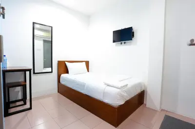 a bedroom with a bed with a mirror and a tv at Lux Hotel in Teluk Intan