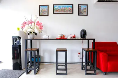 a living room with a table and a red couch at Lux Hotel in Teluk Intan