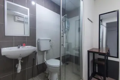 a bathroom with a toilet and a sink and a shower at Lux Hotel in Teluk Intan