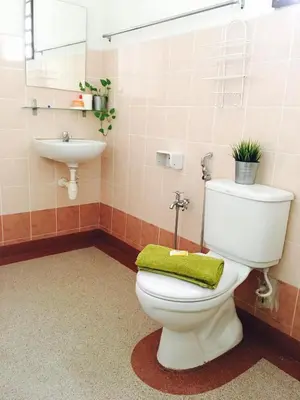 a bathroom with a toilet with a green towel on it at D'Houzz in Sungai Petani