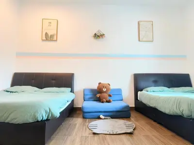 a room with two beds with a teddy bear sitting on a chair at MY SWEETHUB HOMESTAY @ CAMERON HIGHLANDS in Cameron Highlands