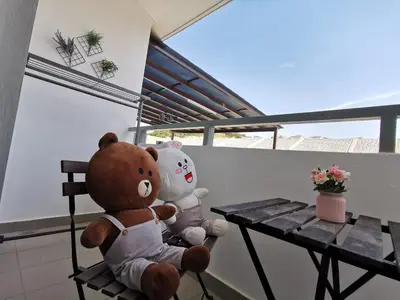 two teddy bears sitting on a chair next to a table at MY SWEETHUB HOMESTAY @ CAMERON HIGHLANDS in Cameron Highlands