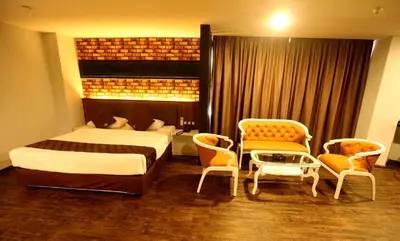 a bedroom with a bed and chairs and a table at Golden Nasmir Hotel in Bukit Mertajam