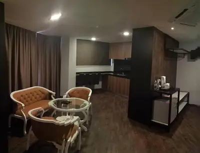 a living room with a glass table and chairs at Golden Nasmir Hotel in Bukit Mertajam
