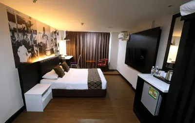 a hotel room with a bed and a television at Golden Nasmir Hotel in Bukit Mertajam