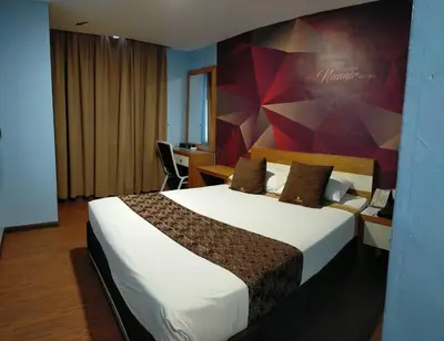 a hotel room with a large bed and a desk at Golden Nasmir Hotel in Bukit Mertajam