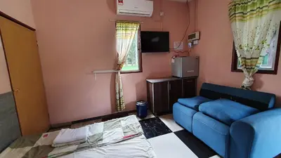 a living room with a blue couch and a tv at Chalet Kampong Semawar in Kuala Kangsar