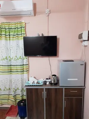 a room with a tv on a wall with a desk with a tvictericter at Chalet Kampong Semawar in Kuala Kangsar