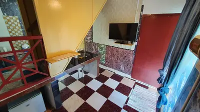 a room with a staircase with a tv on the wall at Chalet Kampong Semawar in Kuala Kangsar
