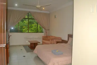 a bedroom with a bed and a desk and a window at Wawa's Golf View Inn in Taiping