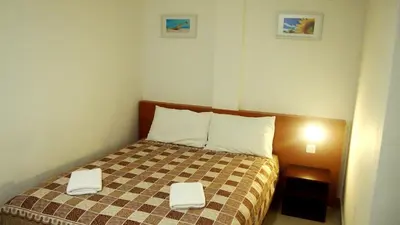 a bedroom with a bed with two towels on it at Aloha Hotel in Lumut