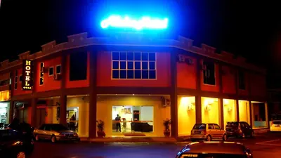 a lit up building with cars parked in front of it at Aloha Hotel in Lumut