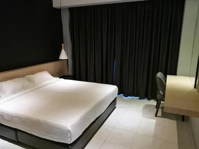 a bedroom with a bed and a desk and a chair at Lumut Waterfront Apartment 62 in Lumut