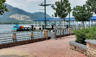 a boat is docked next to a pier with a boat at Lumut Waterfront Apartment 62 in Lumut