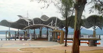a park with benches and a view of the water at Lumut Waterfront Apartment 62 in Lumut