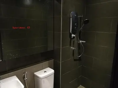 a bathroom with a shower with a toilet and a phone at Lumut Waterfront Apartment 62 in Lumut
