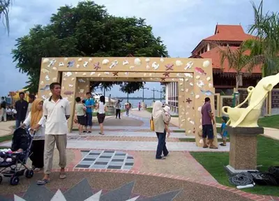 a man and a woman standing in front of a arch at Lumut Waterfront Apartment 62 in Lumut