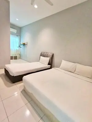 a bedroom with two beds and a chair at Ipoh Meru Animation Homestay by Grab A Stay in Ipoh