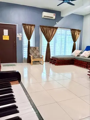 a living room with a piano and a chair at Ipoh Meru Animation Homestay by Grab A Stay in Ipoh
