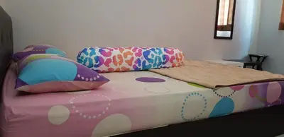 a bed with colorful pillows on top of it at Fahaz Kamunting Taiping in Taiping