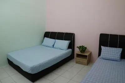 a bedroom with a bed and a night stand at Taiping Cozy Homestay in Taiping