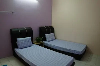 two beds in a room with purple walls at Taiping Cozy Homestay in Taiping