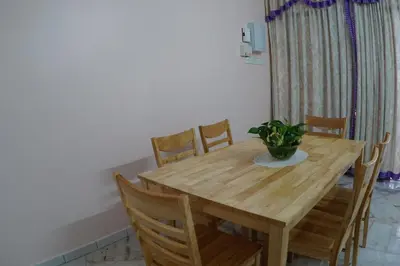 a wooden table with chairs and a potted plant on it at Taiping Cozy Homestay in Taiping