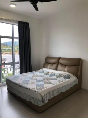 a bed with a quilt on it in a bedroom at Golden Hill 1 Room Apt at Night Market in Cameron Highlands