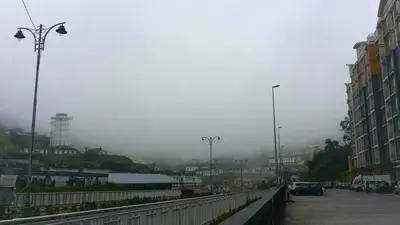 a city street with a bridge and buildings and fog at Golden Hill 1 Room Apt at Night Market in Cameron Highlands