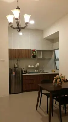 a kitchen with a table and a stainless steel refrigerator at Golden Hill 1 Room Apt at Night Market in Cameron Highlands