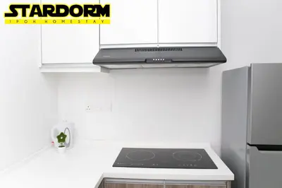 a kitchen with a stove top and a refrigerator at Ipoh City Center Stardorm Ipoh Homestay in Ipoh