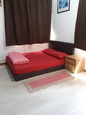 a bedroom with a red bed with a window at 5-MINS WALK TO BEACH WITH POOL, Batu Ferringhi in Batu Ferringhi