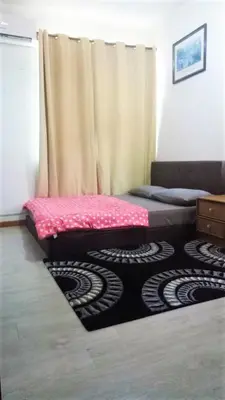 a room with a bed and a curtain and a rug at 5-MINS WALK TO BEACH WITH POOL, Batu Ferringhi in Batu Ferringhi
