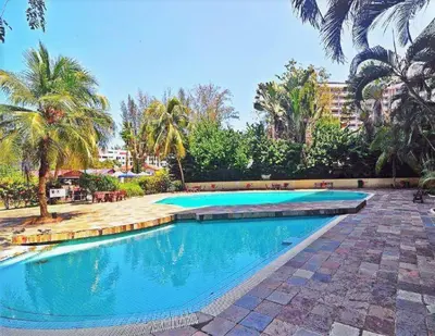 a swimming pool in a resort with palm trees at 5-MINS WALK TO BEACH WITH POOL, Batu Ferringhi in Batu Ferringhi