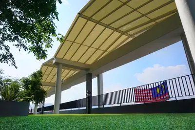 a building with a fence with a flag on it at PM Octagon Ipoh Suites & Apartment 1 in Ipoh