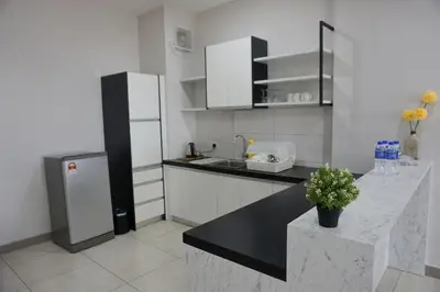 a kitchen with a refrigerator and a black counter top at PM Octagon Ipoh Suites & Apartment 1 in Ipoh