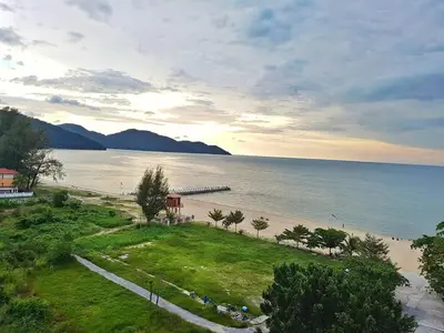 a view of a beach with a dock in the water at By The Sea Duplex Condo in Batu Ferringhi
