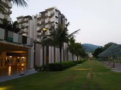 a row of buildings with palm trees next to a street at By The Sea Duplex Condo in Batu Ferringhi