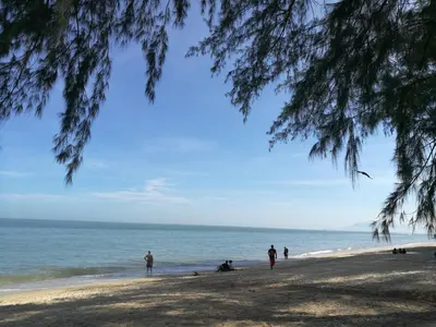 a group of people standing on a beach at By The Sea Duplex Condo in Batu Ferringhi