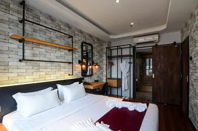 a bedroom with a bed and a brick wall at The Granite Luxury Hotel Penang in George Town