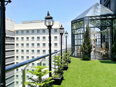 a balcony with a garden and a glass greenhouse at The Granite Luxury Hotel Penang in George Town