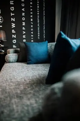 a couch with two blue pillows on top of it at M Boutique Kampar in Kampar